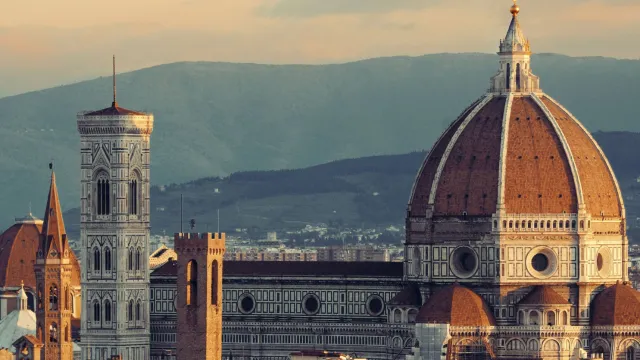 Florence Cathedral at sunset, with distant hills in the background.