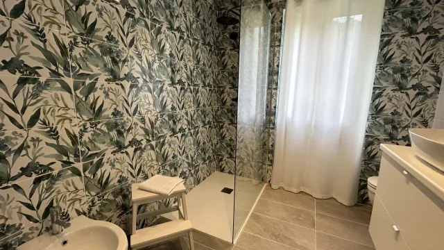 Tropical-themed bathroom with shower, curtain, and bidet.