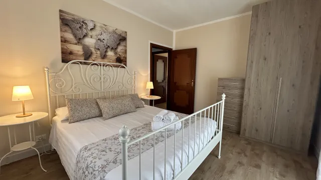 Cozy bedroom with a double bed, lamps, and a wardrobe.