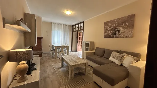 Cozy living room with beige sofa, coffee table, and dining area in the background.