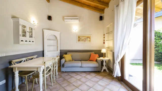 Cozy room with a sofa, dining table, and large window.