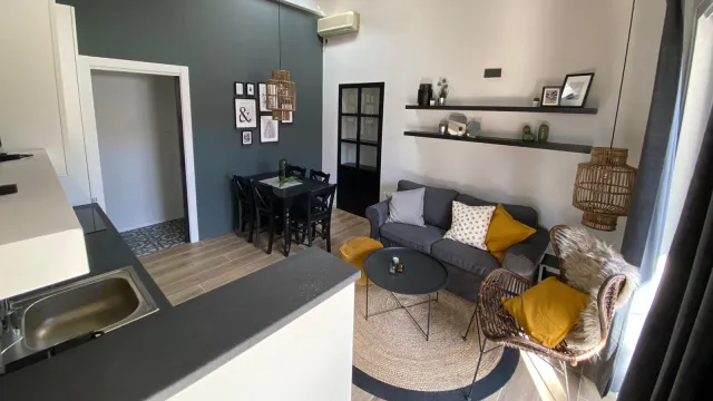 Modern living room with gray sofa, yellow cushions, and wicker chairs.