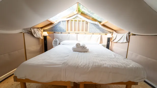 Cozy loft bedroom with white bedding and a skylight.