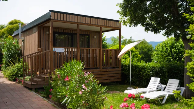 Weekend Loggia with chairs and umbrella in a garden setting.