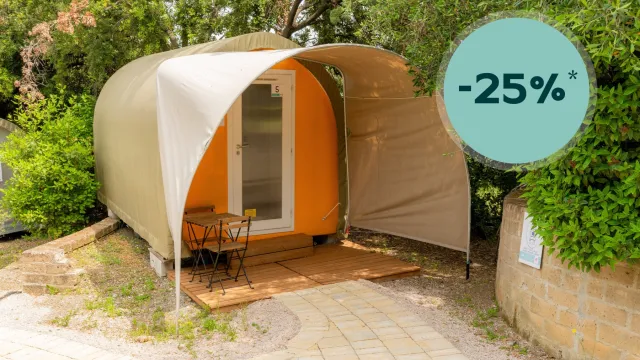 Small glamping tent with patio in a leafy setting, showing a 25% discount badge.
