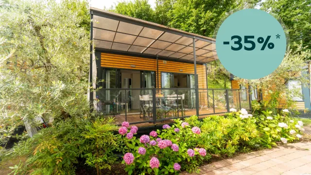 Modern patio with flowers, surrounded by lush greenery.