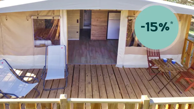 Cabin with wooden deck, lounge chair, and small table set.
