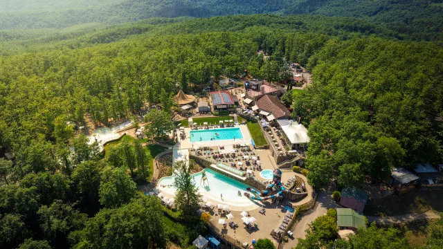Aerial view of a water park surrounded by lush green forest.