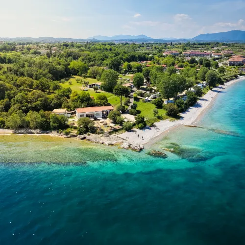 Aerial view of a coastline with turquoise waters and lush green landscape.