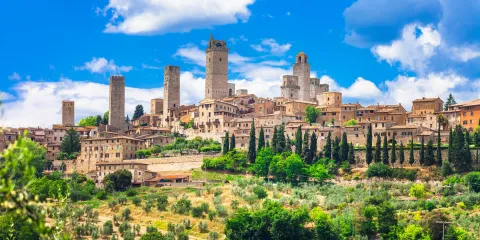 Medieval town with stone towers under a bright blue sky.