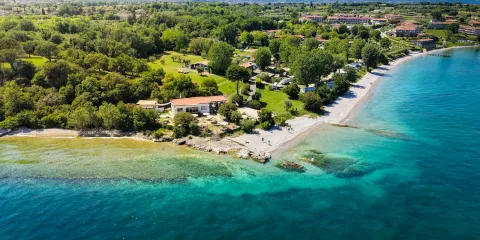 Aerial view of a coastline with turquoise waters and lush green landscape.