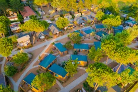 Aerial view of a campground with cabins and trees.