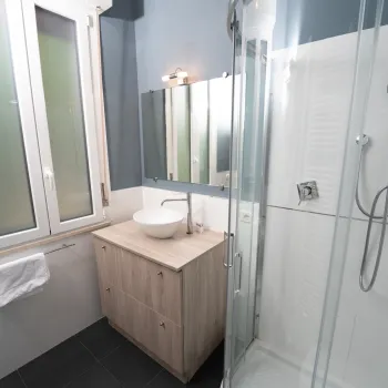 Bathroom with modern sink, mirror, and glass shower.