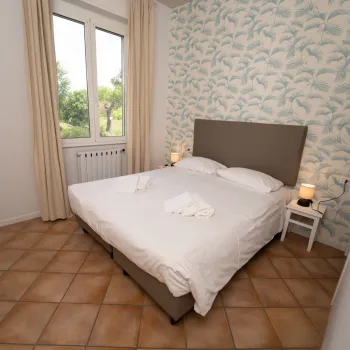 Cozy bedroom with a double bed, floral wallpaper, and soft lighting.