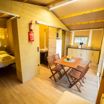 Cozy cabin interior with wood furniture and a small dining area.