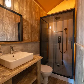 Cozy rustic bathroom with a wooden sink and glass shower.