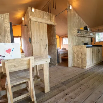 Cozy cabin interior with wooden furniture and warm lighting.