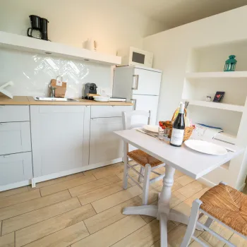 Cozy kitchen with white cabinets and a dining table set for two.