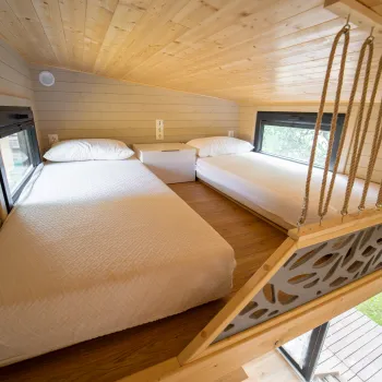 Cozy loft with two beds and wooden decor.