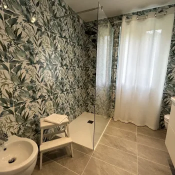 Tropical-themed bathroom with shower, curtain, and bidet.