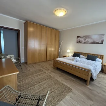 Spacious bedroom with wooden furniture and beige tones.