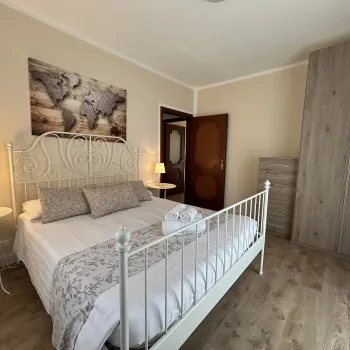 Cozy bedroom with a double bed, lamps, and a wardrobe.
