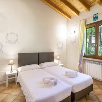 Cozy bedroom with twin beds, wood ceiling, and soft lighting.