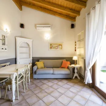 Cozy room with a sofa, dining table, and large window.