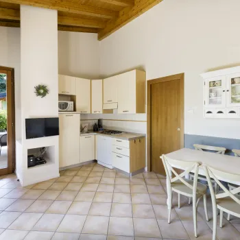 Modern kitchen with white cabinets, dining table, and large window.