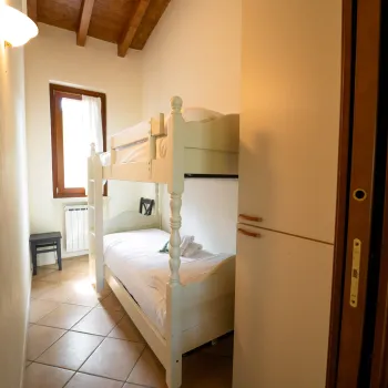 Cozy room with wooden bunk bed and a window.