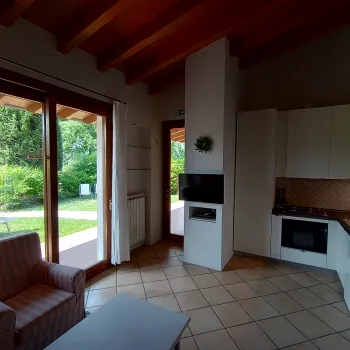 Cozy kitchen with a garden view, tiled floor, and wood ceiling.