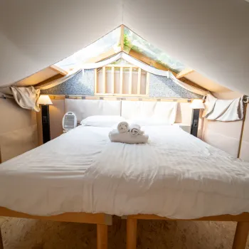 Cozy loft bedroom with white bedding and a skylight.
