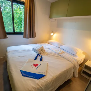 Cozy bedroom with a double bed, bedside lamps, and a window with curtains.