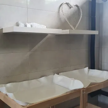 Two-tier changing station with a heart decoration on a shelf.