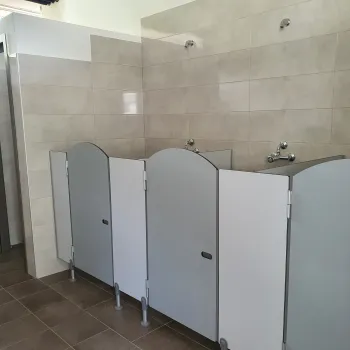 Public restroom with several closed toilet stalls.