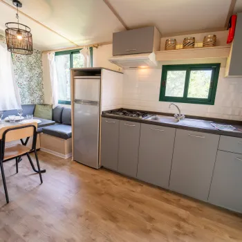Compact kitchen with dining area and gray cabinets.
