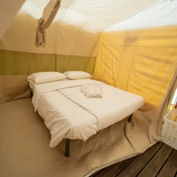 Glamping tent interior with a double bed.