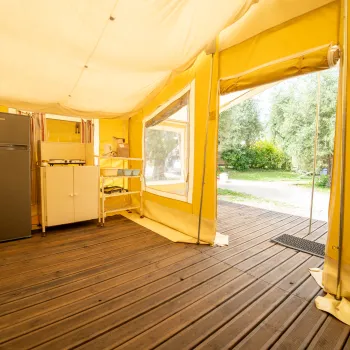 Glamptent  inside view with a fridge, cabinets, and wood flooring.