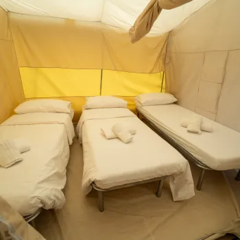 Glamptent 3 neatly made beds with towels.