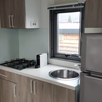 Kitchen with stove, sink, fridge, and cabinets.