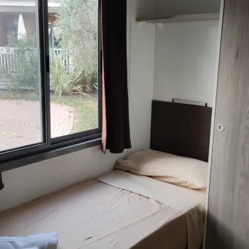 Bedroom with single bed by a window and a wardrobe.