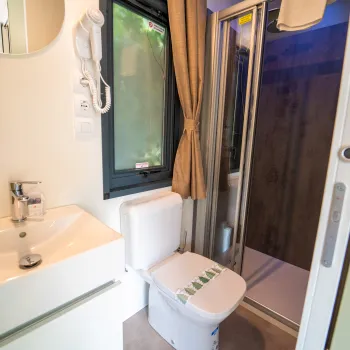 Bathroom with sink, toilet, and glass shower.
