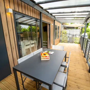 Modern patio with a table, chairs, railings.