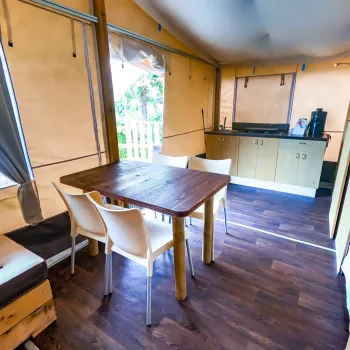 Cozy kitchen with wooden table, white chairs, and light brown cabinets.