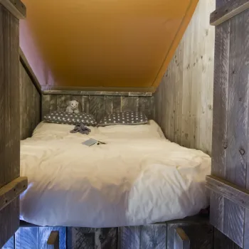 Cozy cabin loft bed with heart-shaped wooden panels.