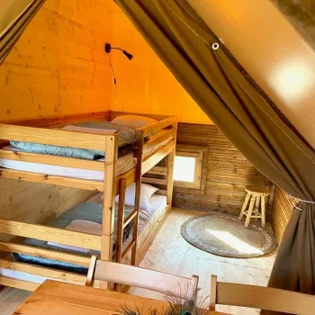 Glamping tent's kids' bedroom with wooden bunk bed