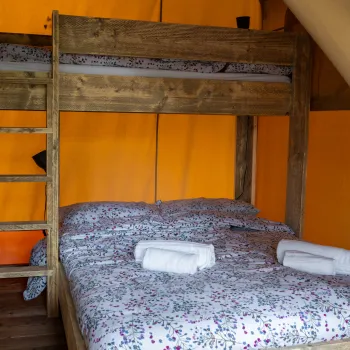Bunk bed with floral sheets in a tent.