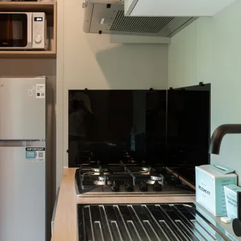 Compact kitchen with stove, fridge, and microwave.