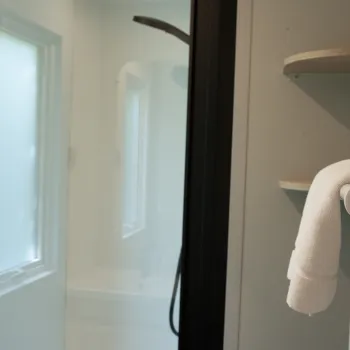 Shower with frosted glass door and towel on a heater.