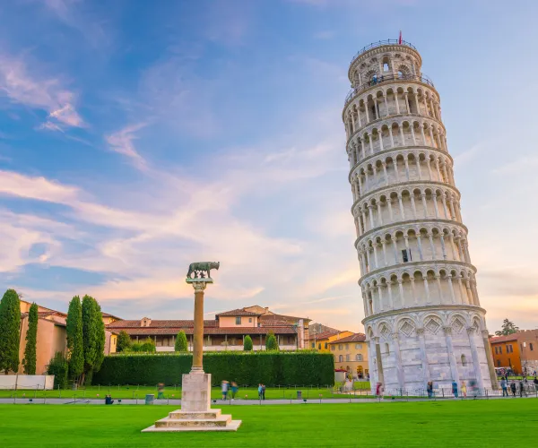 Leaning Tower of Pisa on a sunny day, green lawn, and blue sky.